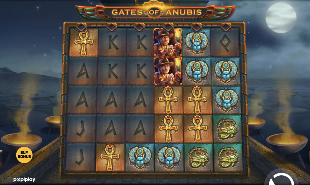 Gates of Anubis online slot game by Popiplay featuring Egyptian-themed symbols like scarabs, ankhs, and Eye of Horus on a 6x5 reel grid, with an adventurer character and a Buy Bonus option visible in a mystical desert night setting