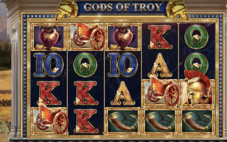Gods of Troy online slot game featuring reels with Greek warrior helmets, chariots, amphora vases, war horns, and golden letter symbols, inspired by ancient Troy mythology.