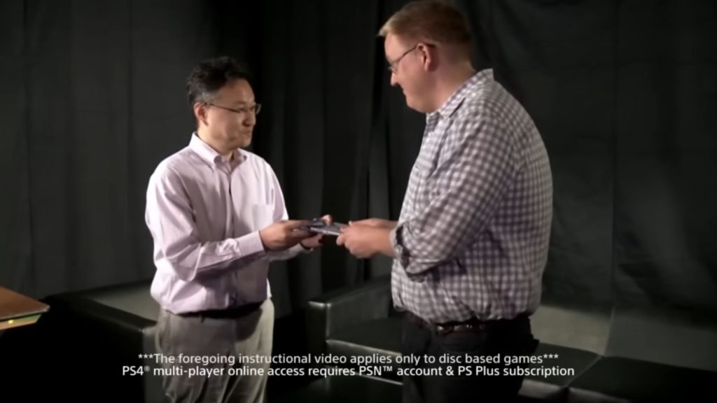Shuhei Yoshida and Adam Boyes exchanging playstation game